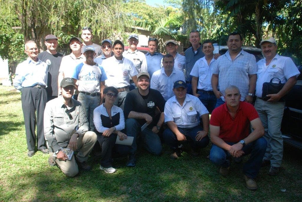 A large group of farmers and visitors gathered outdoors at a farm