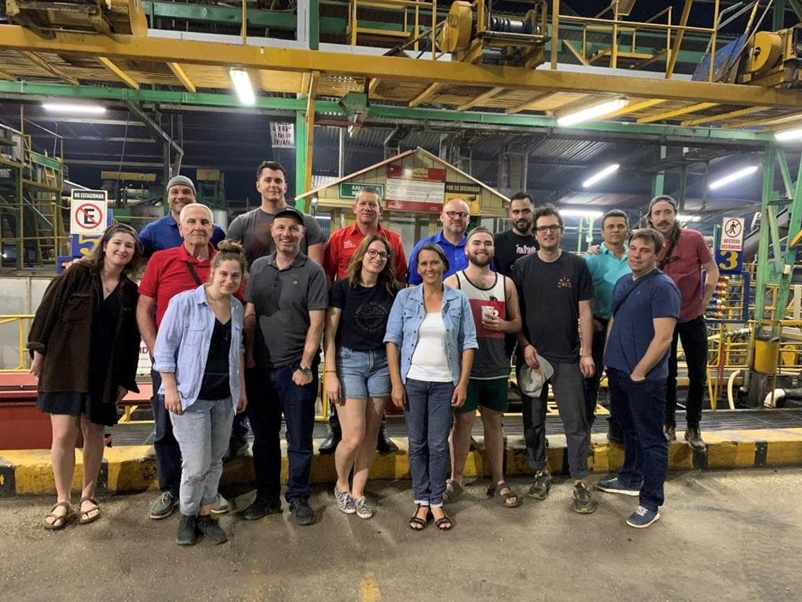 Group standing inside a working coffee processing plant